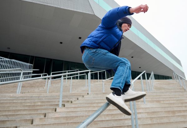 Ung mand der laver parkour på en trappe.